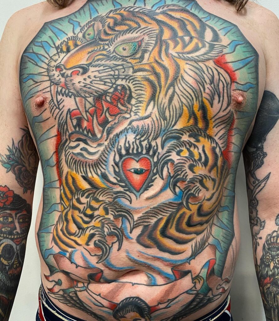 Tatuaje japonés tradicional de tigre a todo el pecho, con colores intensos y detalles en negro, hecho en Barcelona.
