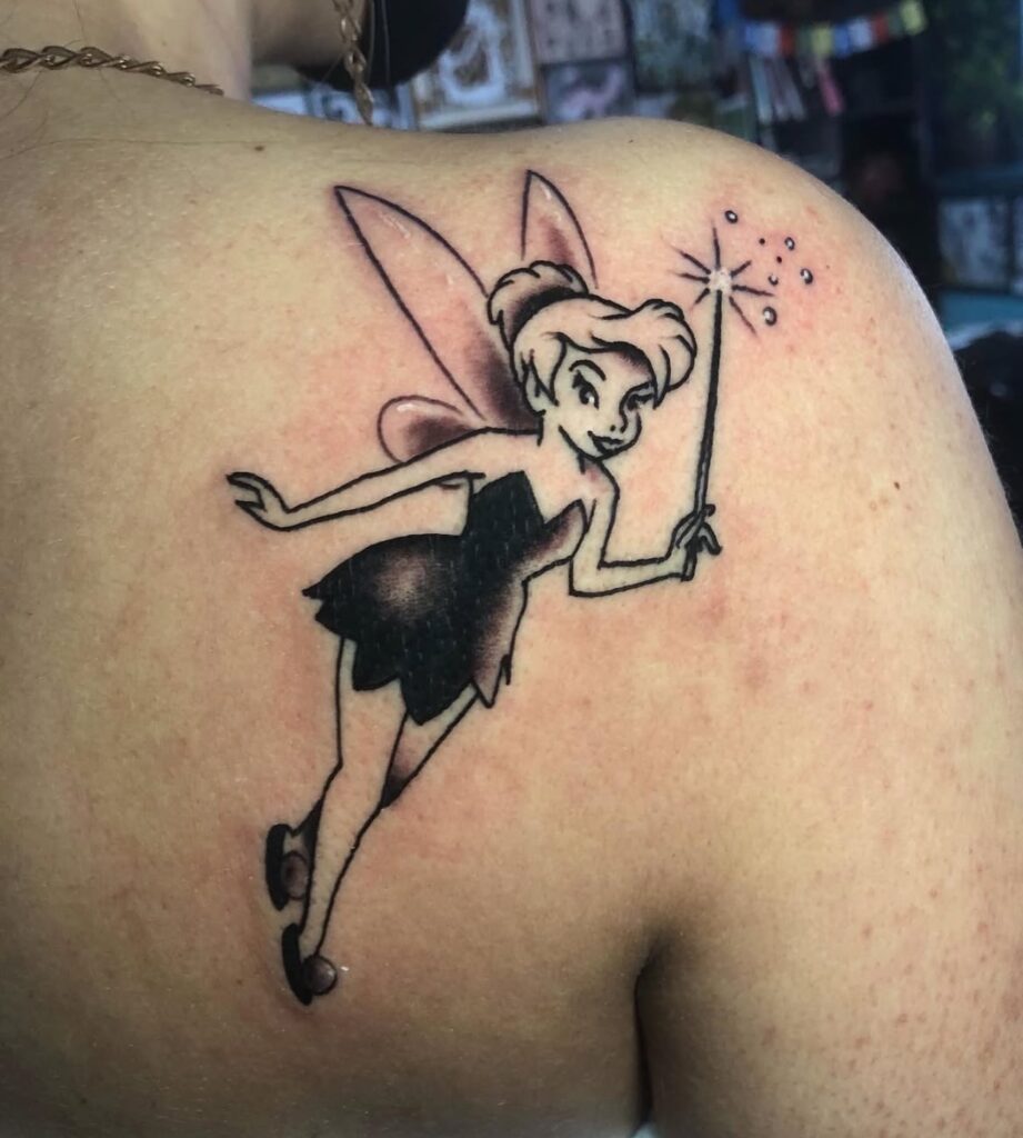 Tatuaje de Campanilla con varita mágica en estilo sombreado, hecho en Barcelona.
