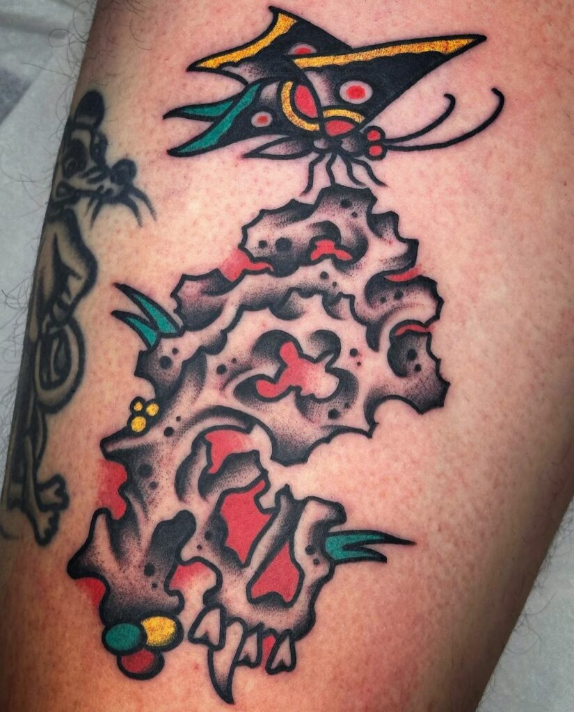 Tatuaje neotradicional de calavera con mariposa de colores, realizado en Barcelona