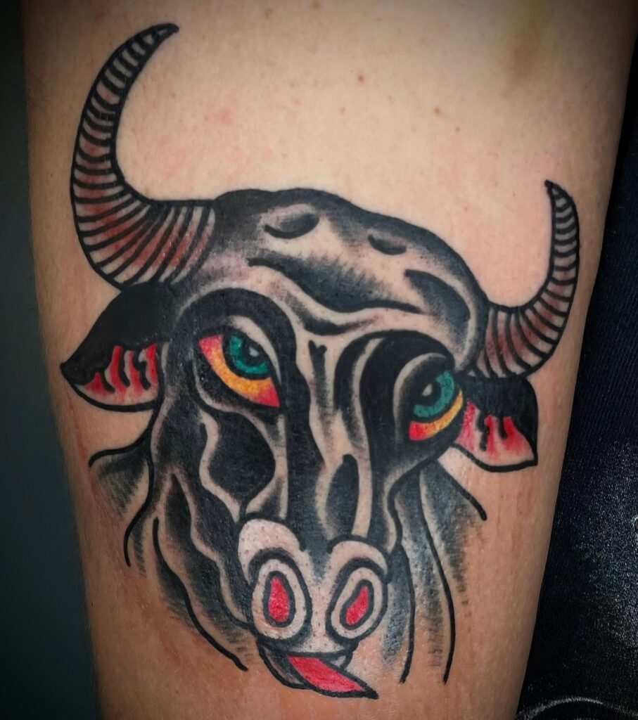 Tattoo de un toro en estilo tradicional americano, con colores negros, rojos y verdes, realizado en Barcelona.
